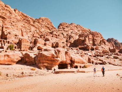 Dos turistas junto a las cuevas y tumbas reales de la antigua ciudad de Petra (Jordania)