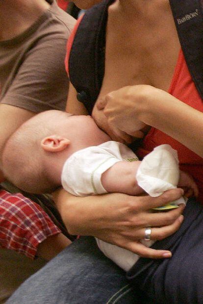 Una mujer da de mamar a su hijo.