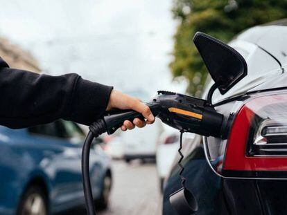 Una persona carga un coche eléctrico.