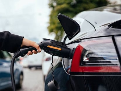 Una persona carga un coche eléctrico.