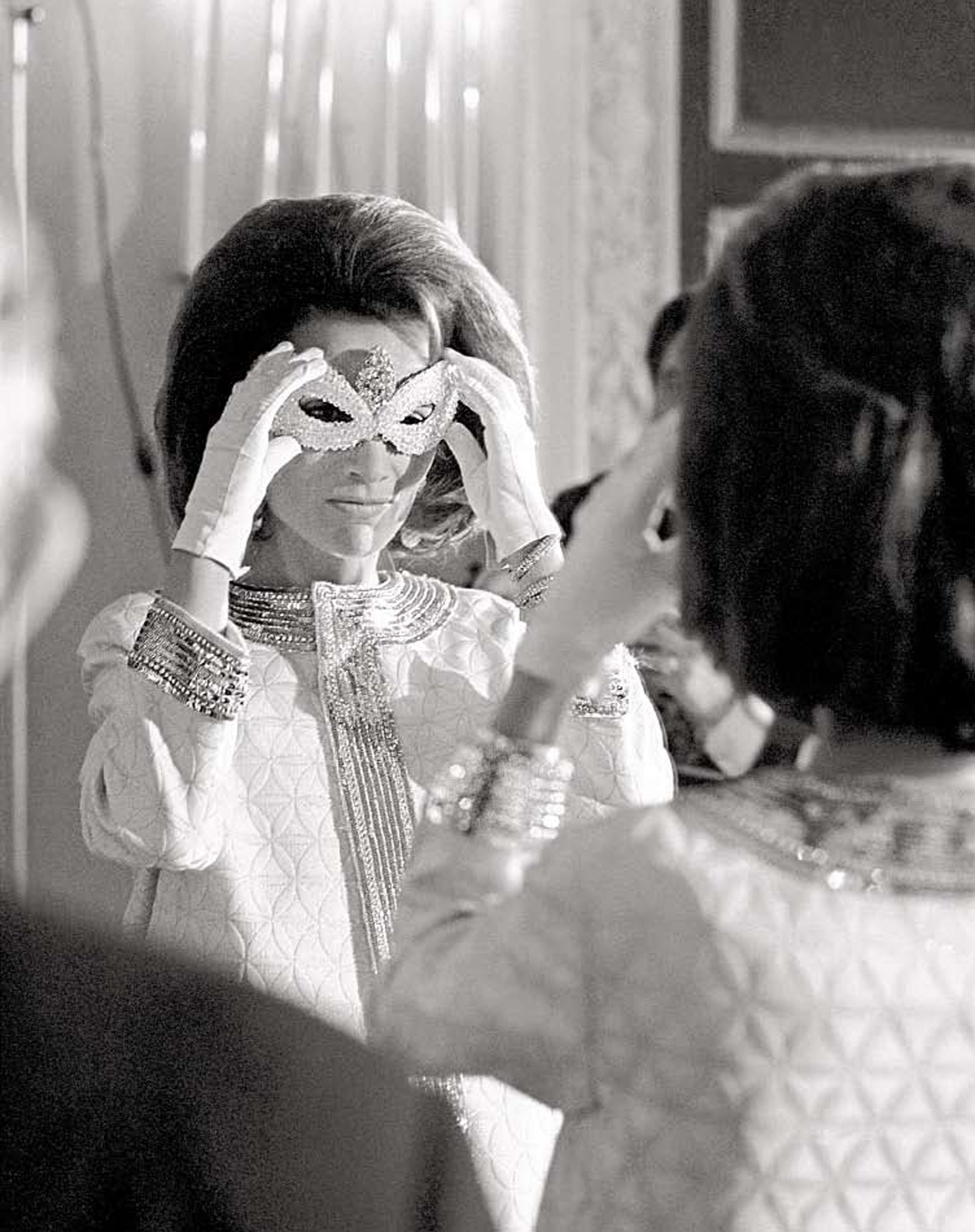 La prrincesa Lee Radizwell, hermana de Jackie Kennedy, se ajusta la máscara después de llegar al baile.