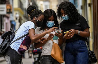 Tres chicas usan su móvil en La Habana el 14 de julio de 2021.