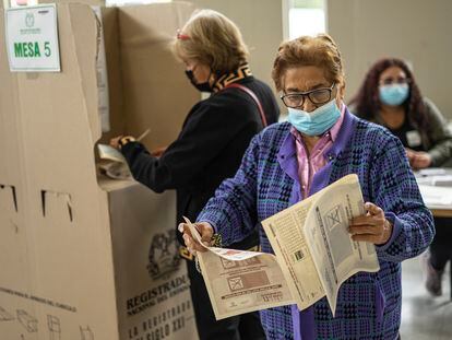 Una mujer se prepara para depositar su voto en una urna en un colegio de votación en Bogotá Colombia, el 13 de marzo de 2022.