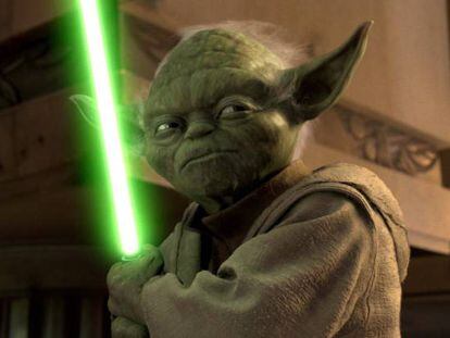 Yoda, personaje de La guerra de las galaxias, con su arma.