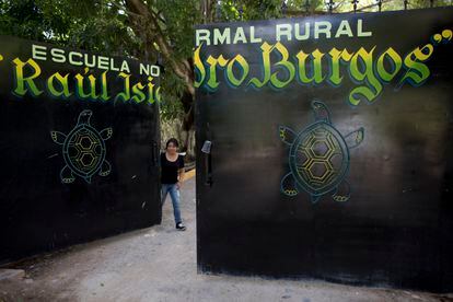 Una estudiante cierra la puerta de entrada a la escuela Normal Rural Raúl Isidro Burgos de Ayotzinapa, en octubre de 2014.