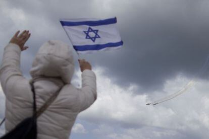 Una mujer sostiene una bandera israel&iacute; durante una demostraci&oacute;n militar, este jueves en Tel Aviv.