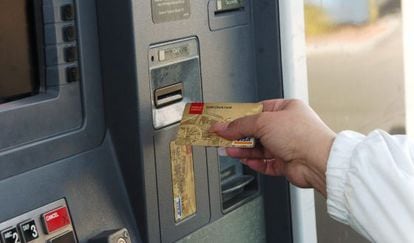 Una mujer saca dinero de un cajero automático.