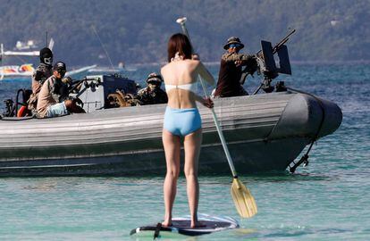 Los botes tienen prohibido navegar en un radio de tres kilómetros alrededor de la isla y sólo los habitantes de Boracay podrán pescar en las aguas. En la imagen, una turista navega sobre una tabla de paddle cerca de los soldados que se preparan para el cierre de la isla, el 24 de abril de 2018.