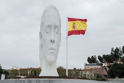 Busto de Jaume Plensa y la bandera 294 metros cuadrados que ondea en la plaza desde 2001. A la derecha se intuye el conjunto monumental de los Jardines del descubrimiento. ! 