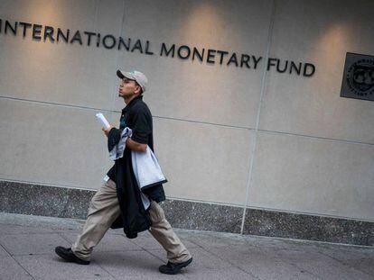 un hombre pasa ante la sede del FMI en Washington