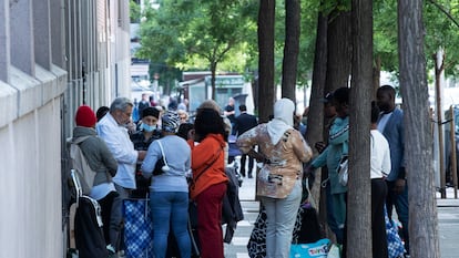 Varias personas esperando para recoger alimentos en la Fundación Karibu (Madrid).