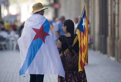 Un hombre con una 'etreleira' ataviada pasea junto a una mujer que empuña una 'estelada' esta mañana en Barcelona.