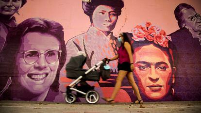 Una mujer camina junto al mural restaurado de las mujeres del barrio de Ciudad Lineal en Madrid, este sábado.