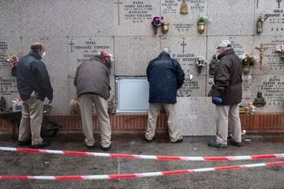 Una cuadrilla de enterradores sella un nicho en el Cementerio Sur de Madrid, este lunes.