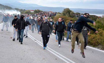 Un grupo de manifestantes lanzan piedras a los antidisturbios, este miércoles en Lesbos.