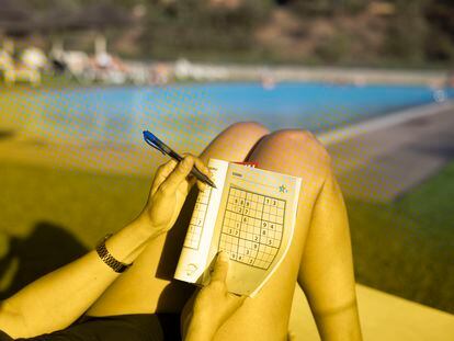 Una mujer hace un sudoku en una piscina de Barcelona el 25 de julio del 2023.