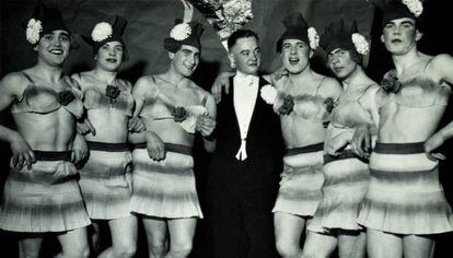 Hombre en esmoquin rodeado de seis travestis. Alemania, invierno de 1937.