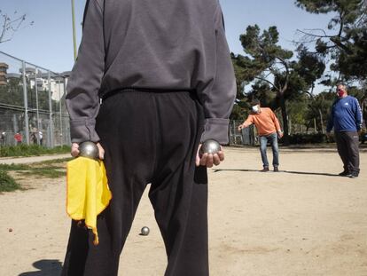 Un jugador sostiene sus bolas durante una partida de petanca en el parque de Aluche.