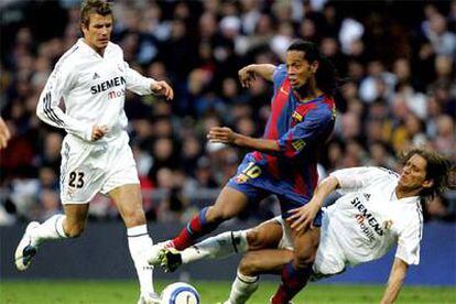Míchel Salgado frena un avance de Ronaldinho en presencia de Beckham.