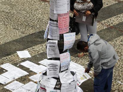 Dos personas leen ofertas de trabajo en una de las principales calles de São Paulo (Brasil)