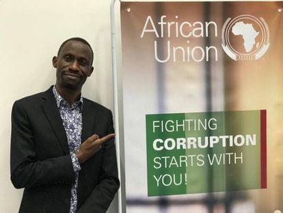 Maxence M. Melo, uno de los fundadores de la plataforma Jamii Forums, ante un cartel de la Unión Africana que alienta la lucha contra la corrupción.