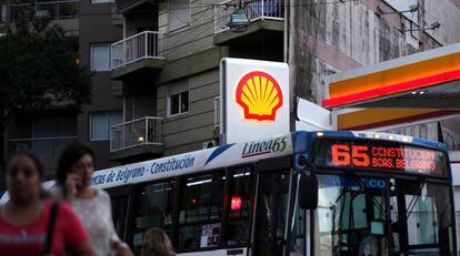 Un autobús cruza frente a una gasolinera de Shell en Buenos Aires.