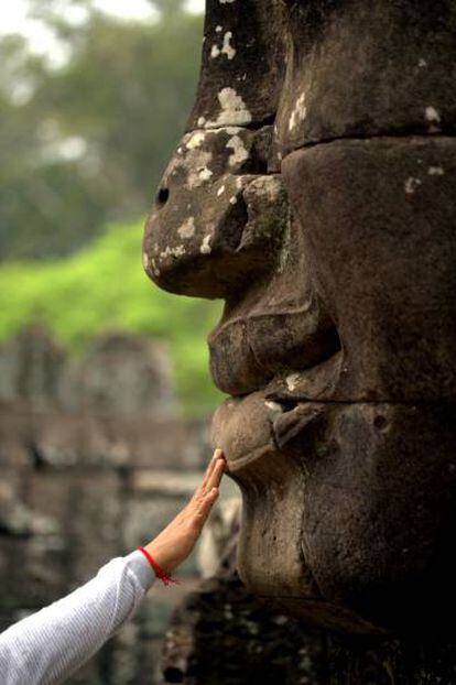 Un peregrino hindú ante uno de los rostros gigantes del templo de Bayón, en Angkor Thom.