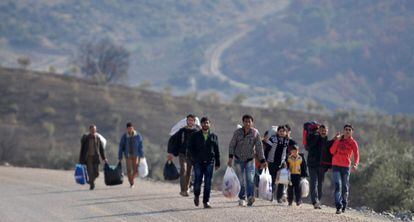 Civiles sirios huyen de la guerra y tratan este miércoles de cruzar la frontera hacia Turquía.
