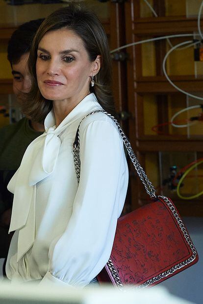 Para asistir a un acto en Teruel en septiembre, la Reina escogió un bolso de piel roja cortada al láser con estampado de caras y cadena plateada de Zara (69,95 euros). Aunque en la foto no se aprecia, lo combinó con pantalón de cuadros de Mango.