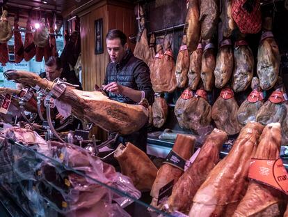 Un empleado corta jamón en una charcutería de Valencia.