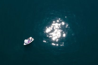 Una fotografía tomada desde un dron muestra a varias personas en un bote bajo el sol del verano en el Lago Lemán de Ginebra, Suiza.