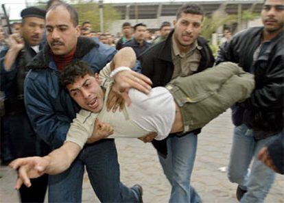 Un grupo de palestinos traslada a uno de los heridos en la incursión.