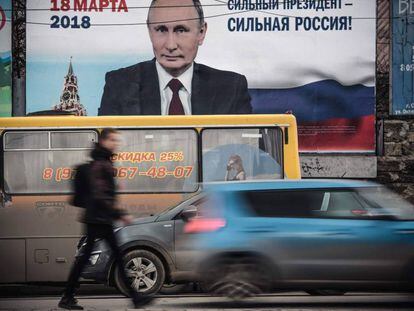 Un hombre pasa delante de un afiche electoral en favor de la candidatura del presidente de Rusia, Vlad&iacute;mir Putin, &quot;&iexcl;Un presidente fuerte, una Rusia fuerte!&quot;, en Crimea. 