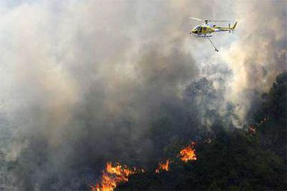 Un helicóptero participa en la extinción del fuego.