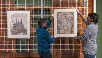 Dos operaris del MNAC, amb els dos dibuixos de Gaudí que acaben d'ingressar al museu.