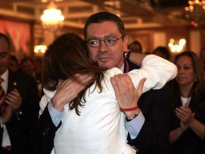 El alcalde Alberto Ruiz-Gallardón abraza a su esposa, Mar Utrera, tras producirse la eliminación de Madrid. A la derecha, la concejal socialista Trinidad Jiménez.