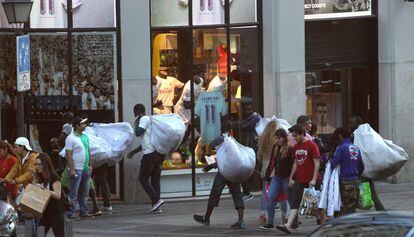 Unos recogen su mercancía en el centro de Madrid.
