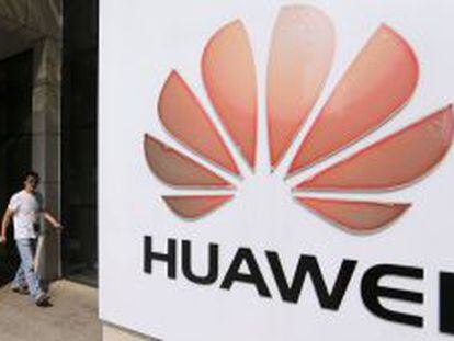 Un hombre pasea junto a un logo de Huawei, en la sede central de la compa&ntilde;&iacute;a.