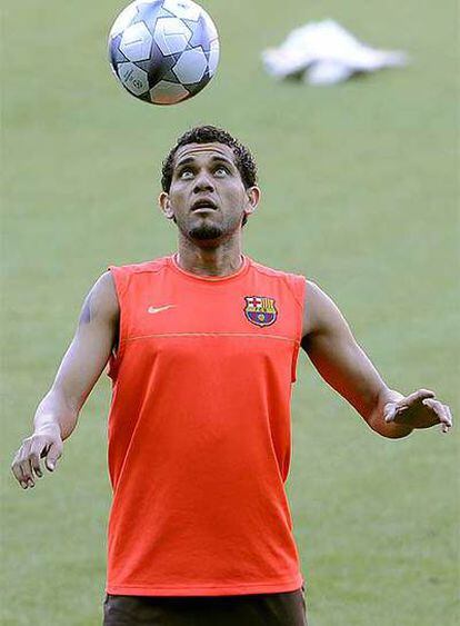 Dani Alves hace malabarismos con el balón durante el entrenamiento de ayer del Barcelona.
