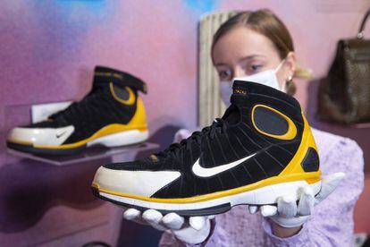 Una empleada de Sotheby’s sostiene un par de zapatillas Nike con las que jugó el exjugador de Los Ángeles Lakers Kobe Bryant, fallecido en un accidente aéreo en enero de 2020. La casa de subastas cree que se venderán entre 23.000 y 33.000 euros.