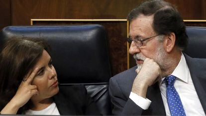 El presidente del Gobierno, Mariano Rajoy, habla con la vicepresidenta, Soraya S&aacute;enz de Santamar&iacute;a, durante el pleno del Congreso.