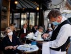 A waiter wearing a face mask serves at Cafe de Flore, as restaurants and cafes reopen following the coronavirus disease (COVID-19) outbreak, in Paris, France, June 2, 2020. REUTERS/Christian Hartmann