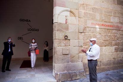 El director artístico del Museo Picasso, José Lebrero, y su primera visitante aplauden tras reabrir los portones del Palacio de Buenavista que alberga la pinacoteca tras más de dos meses cerrado debido a la pandemia.