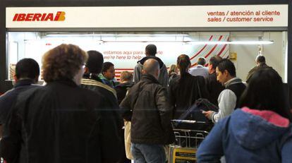 Pasajeros consultan los mostradores de atenci&oacute;n al cliente de Iberia en la T4 del aeropuerto madrile&ntilde;o de Barajas.