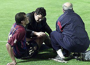 Rivaldo recibe la atención del médico y del masajista del Barça, el sábado, en Balaídos.