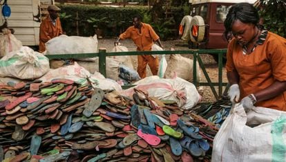 Empleados de Ocean Sole abren sacos con chancletas usadas procedentes de Nairobi y la costa de Kenia.