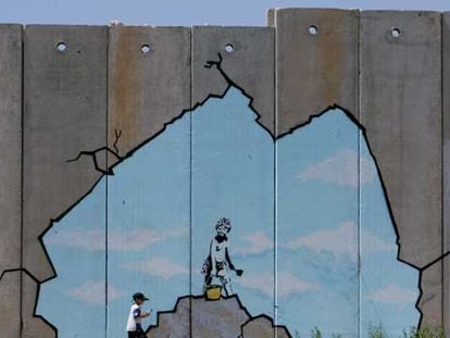 Un niño palestino pasa junto a una de las pinturas del muro de Gaza.