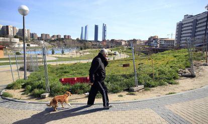 Un hombre pasea con su perro por el vallado parque Agust&iacute;n Rodr&iacute;guez Sahag&uacute;n de Madrid. 