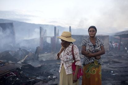 Mujeres en los restos que todavía arden después de un incendio en un mercado en Puerto Príncipe, Haití.
