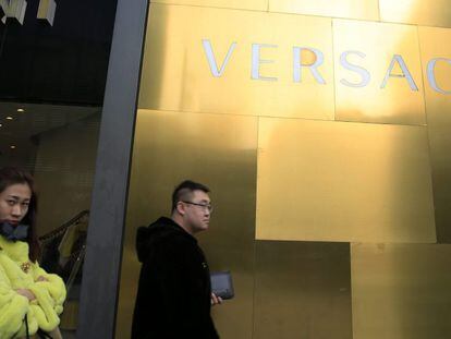 Un grupo de personas camina frente a una tienda de lujo en Pek&iacute;n (China), el 25 de febrero de 2016.